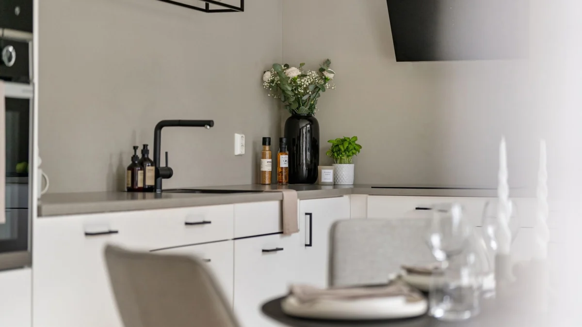 Keukens die praktisch en stijlvol tegelijk zijn Strakke minimalistische keukeninterieur met decor, witte kasten en moderne apparaten.